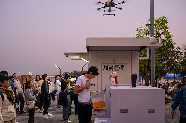 在深圳，外國(guó)游客體驗(yàn)無(wú)人機(jī)外賣送餐。